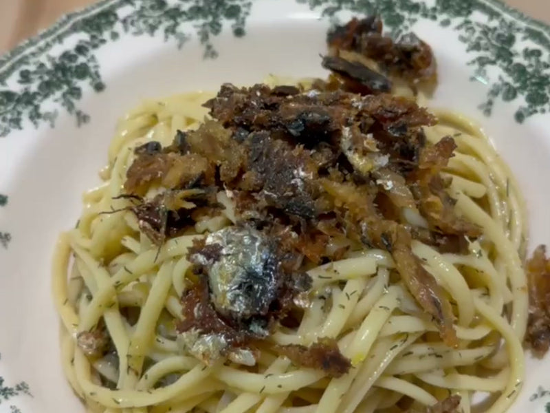 A plate of spaghetti with sardines and a crisp sardine crumb